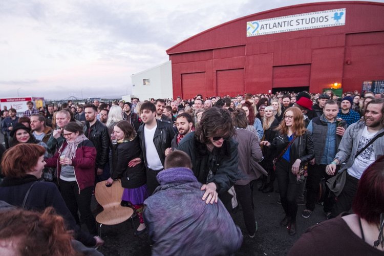 Menschen vor den Atlantic Studios genießen eine Veranstaltung bei Sonnenuntergang.