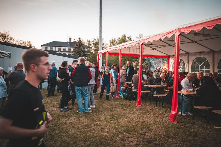 Neighbours gathering around a red and white marquee.