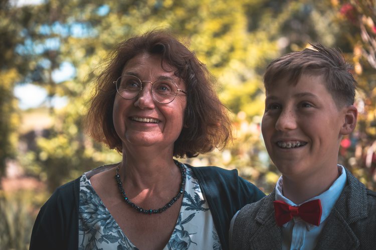 Zwei Familienmitglieder lachen gemeinsam im Garten.