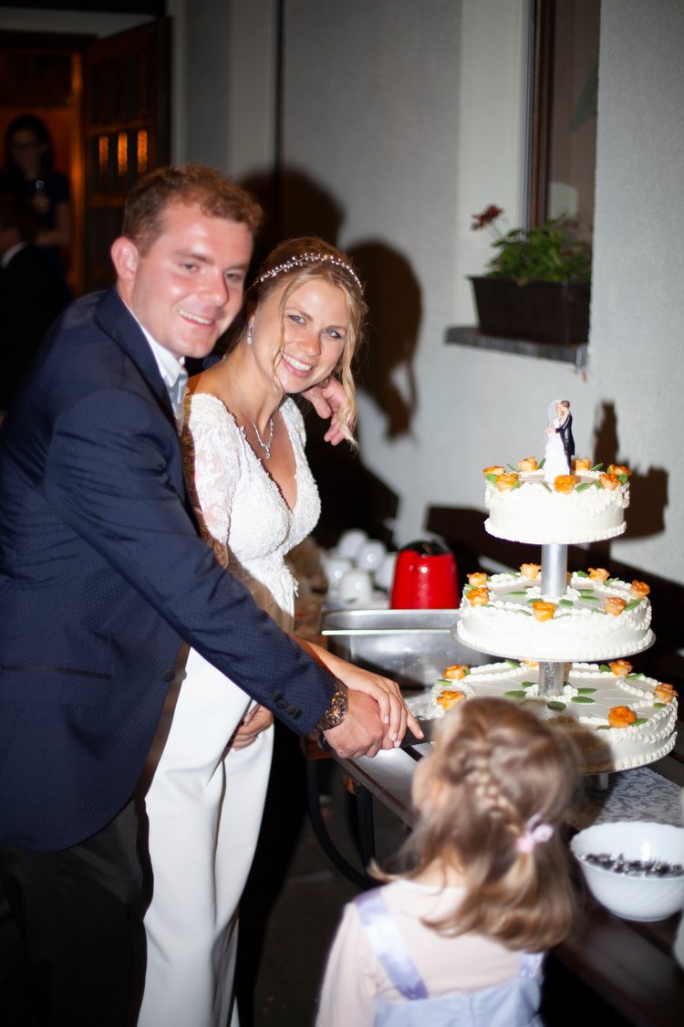 Das Paar schneidet gemeinsam die Hochzeitstorte an.