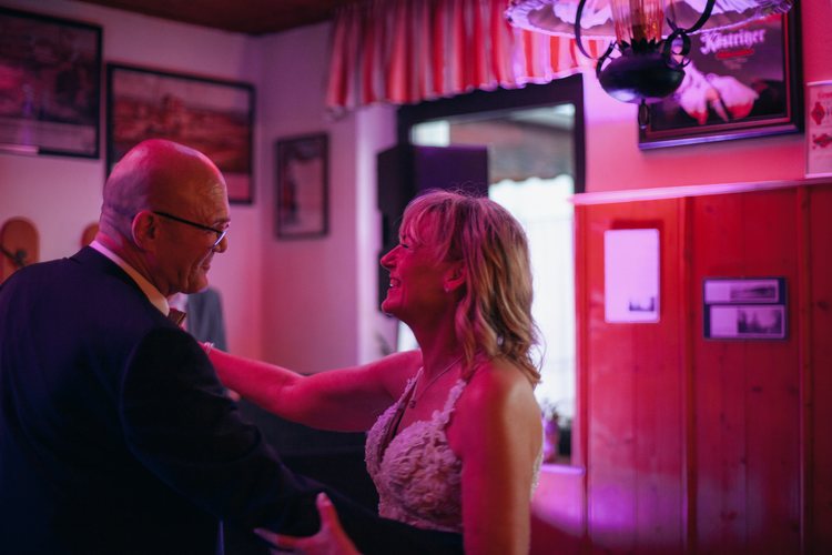 Das Hochzeitspaar tanzt im violetten Abendlicht.